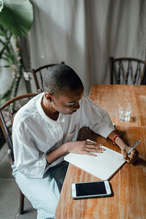 Una persona escribiendo en un cuaderno