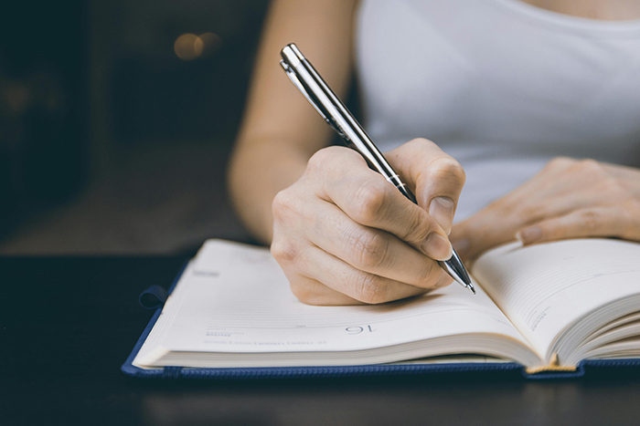 Una mujer escribiendo en un cuaderno