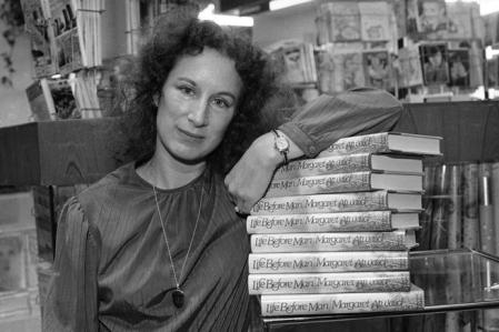 Margaret Atwood apoyada en una pila de libros